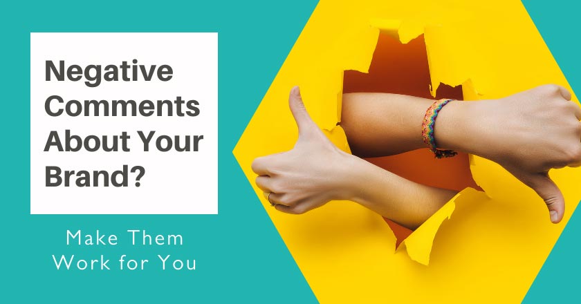 The image features a bright and engaging design. On the left side, there is a teal-colored background with white text that reads, "Negative Comments About Your Brand? Make Them Work for You." On the right side, a pair of hands bursts through a yellow paper wall, with one hand giving a thumbs-up and the other giving a thumbs-down, symbolizing the mixed nature of feedback. The visual conveys the message that negative comments can be turned into positive outcomes for a brand. The overall design is bold, dynamic, and focused on leveraging both positive and negative feedback for improvement.