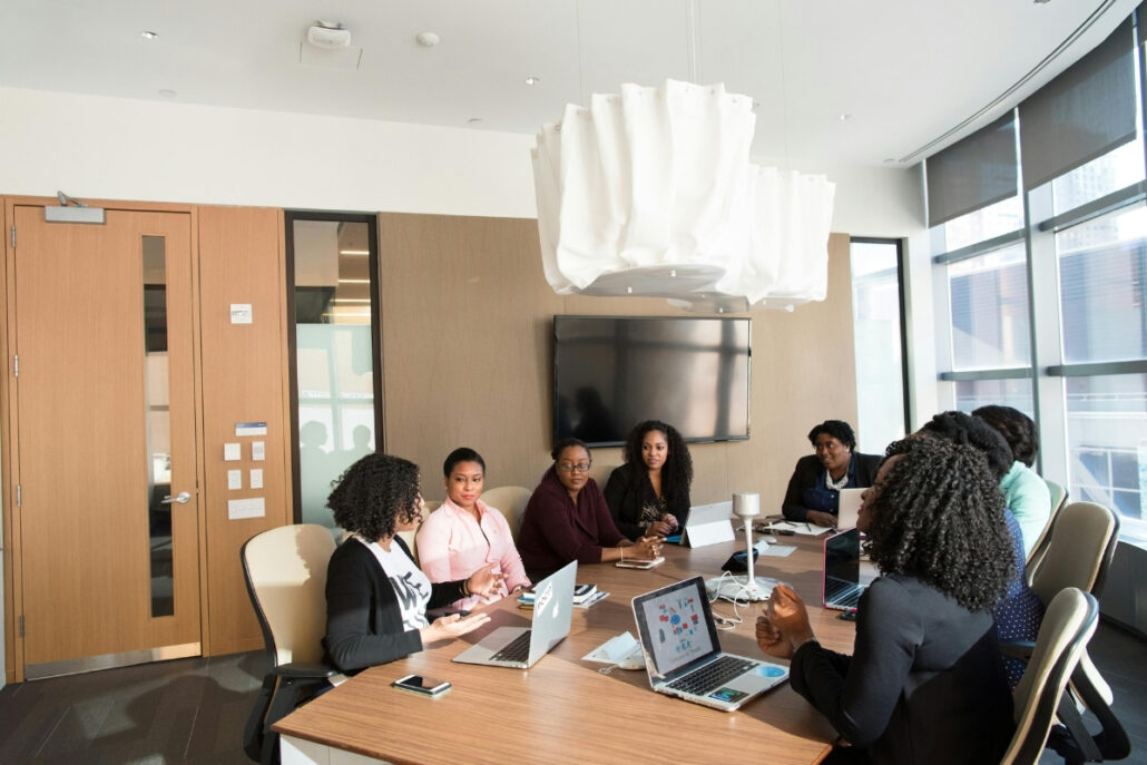 A diverse group of professionals engaged in discussion around a conference table during a meeting.