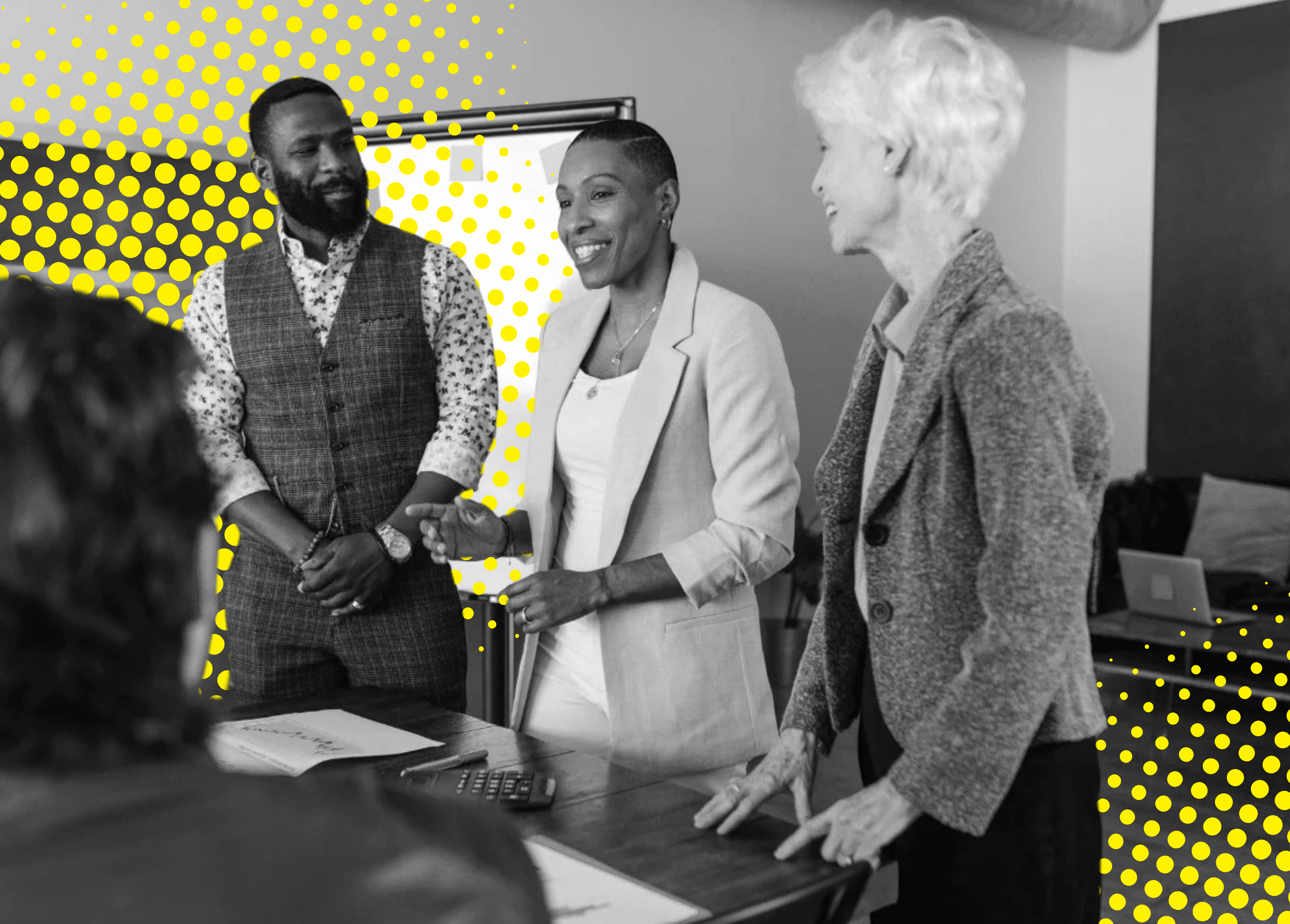 Three professionals standing and discussing over a table in a monochrome setting with a yellow dotted background.