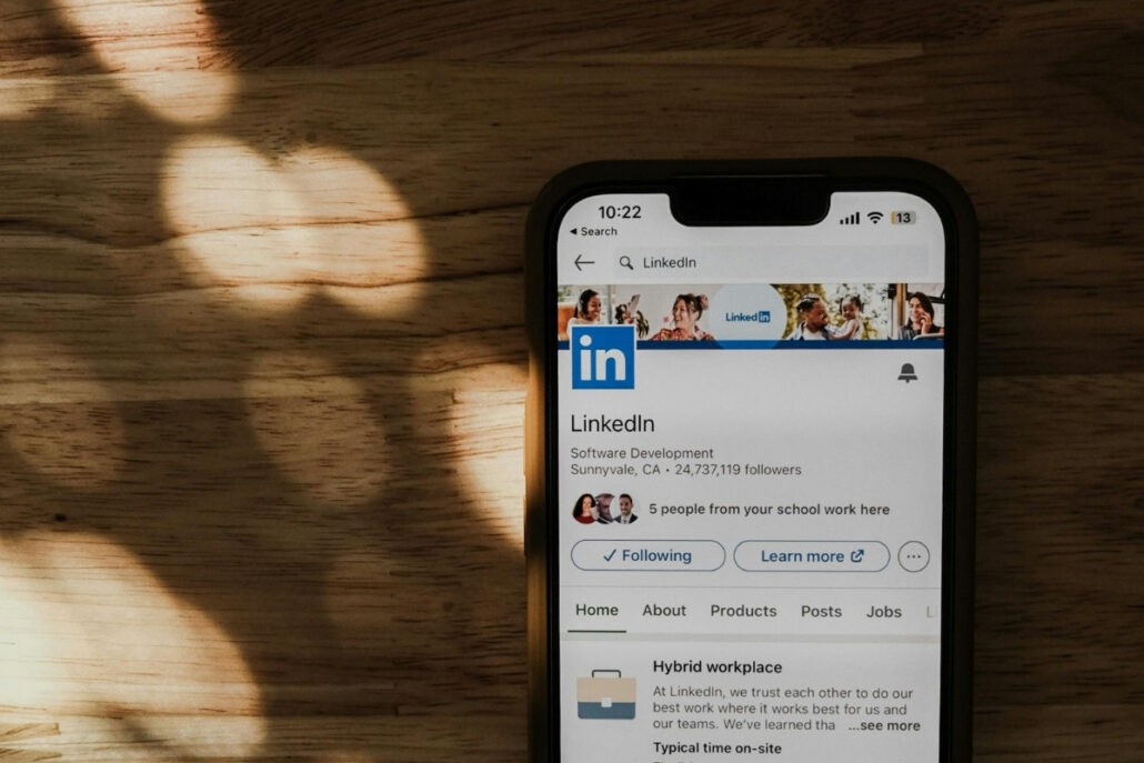 Phone screen with LinkedIn's profile under soft shadow lighting.