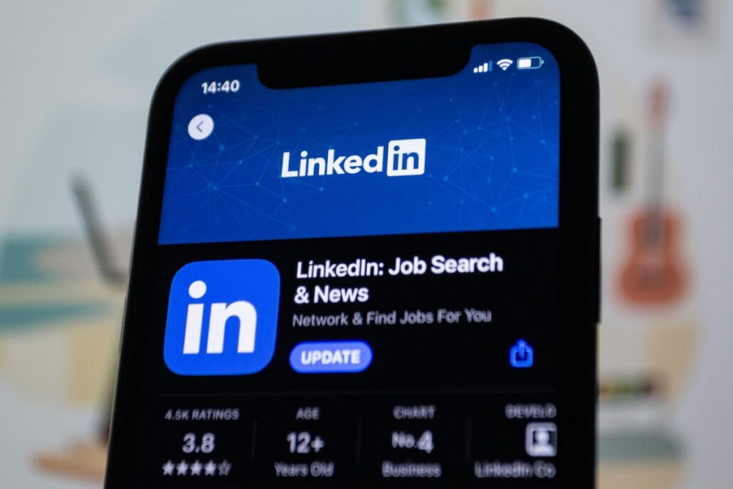 Close-up of LinkedIn app description on a phone screen in a well-lit environment.