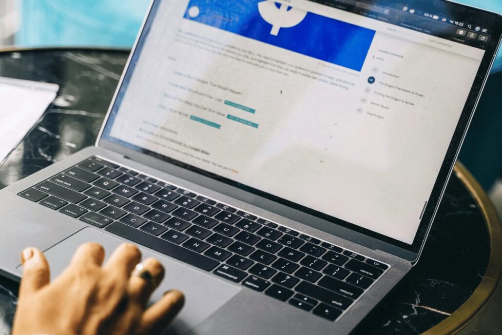 Close-up of a laptop showing an e-learning dashboard with course modules.
