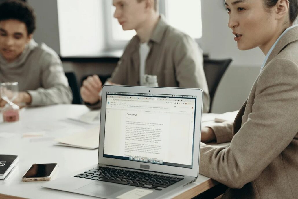 Business meeting with a laptop showing a recap document.