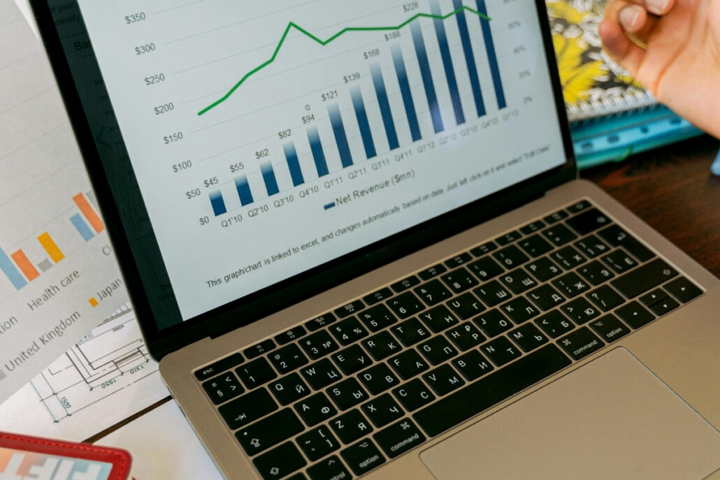 A laptop screen displaying a bar and line chart showing net revenue growth over multiple quarters.